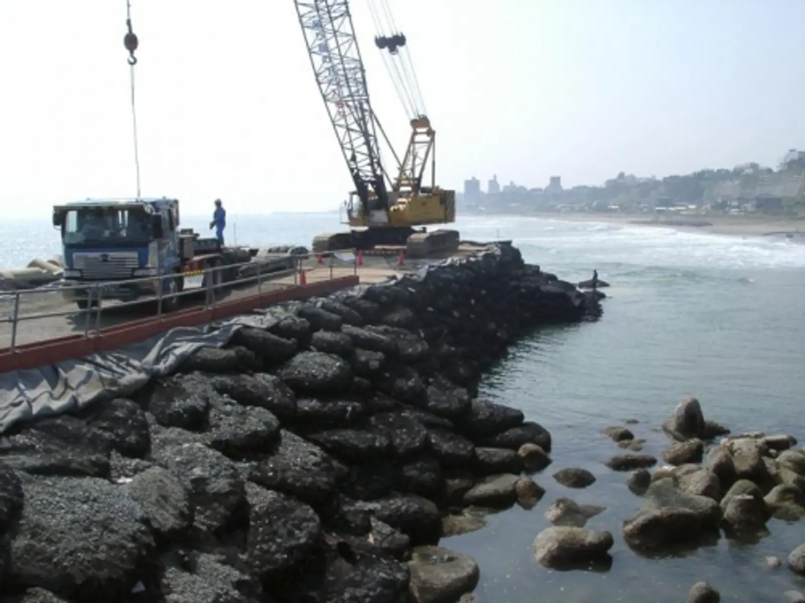 Emergency temporary road and river crossing built with rock bags