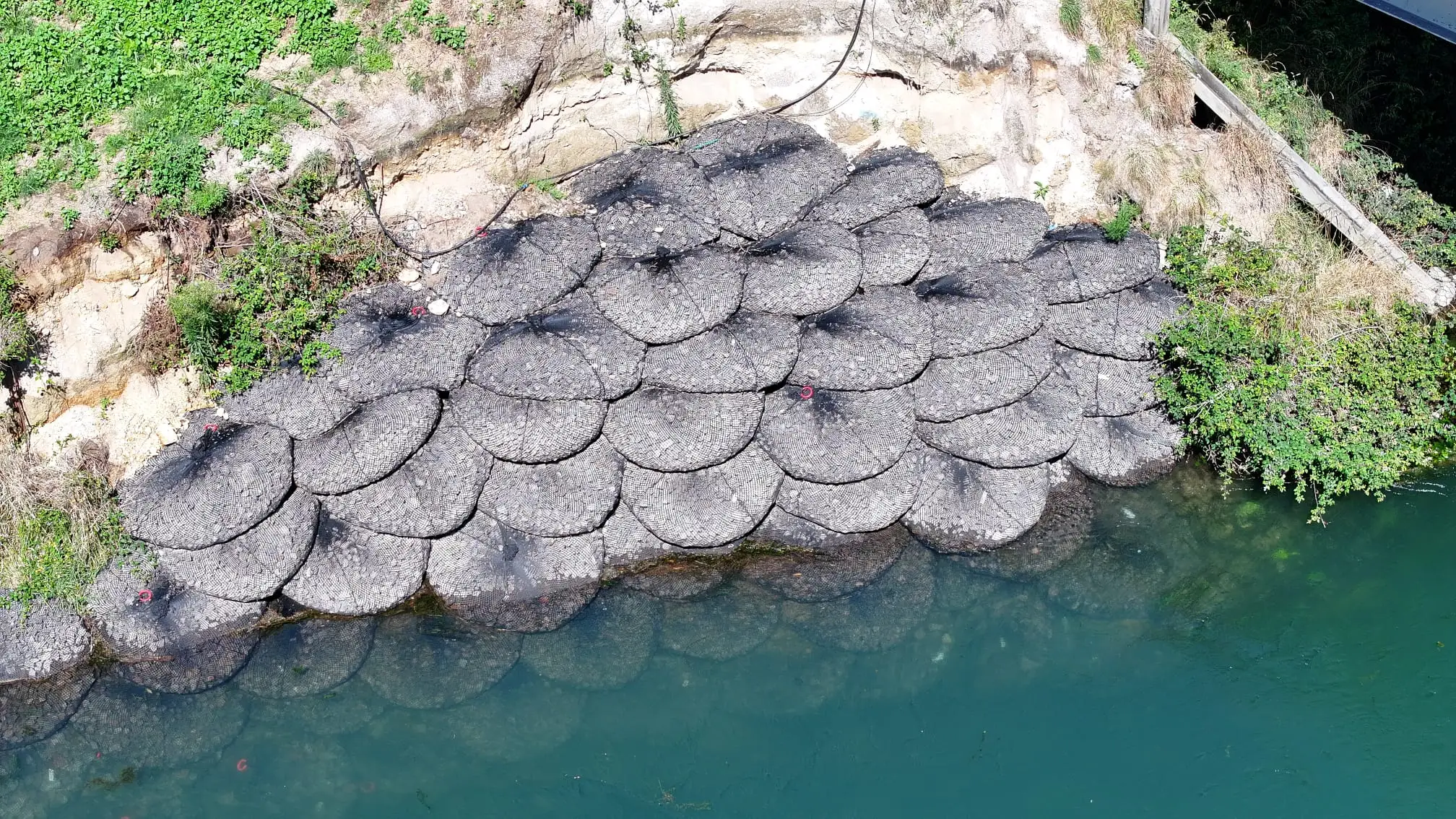Aerial view of Texas Tuff Rock Bags placed as a revetment mat along a riverbank