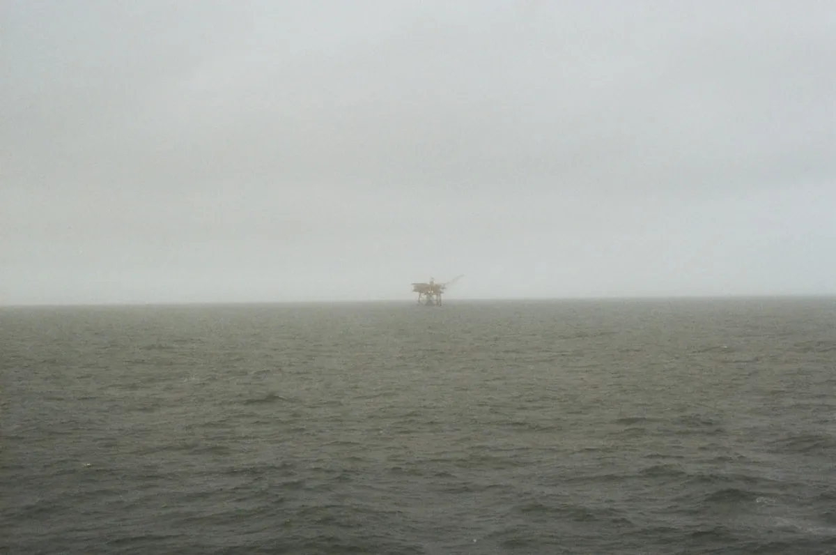 Offshore oil platform jacket leg with rock bag seabed armor protecting a riser, Gulf of Mexico