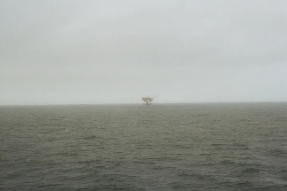 Offshore oil platform jacket leg with rock bag seabed armor protecting a riser, Gulf of Mexico