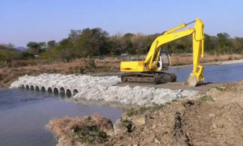Emergency temporary road and river crossing built with rock bags — photo 2